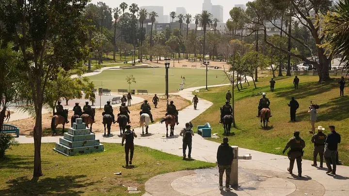 ICE Raid at MacArthur Park Sparks Backlash in L.A. 1 ICE federal agent at MacArthur Park, on Monday in Los Angeles. (Image Credit: Damian Dovarganes/AP)