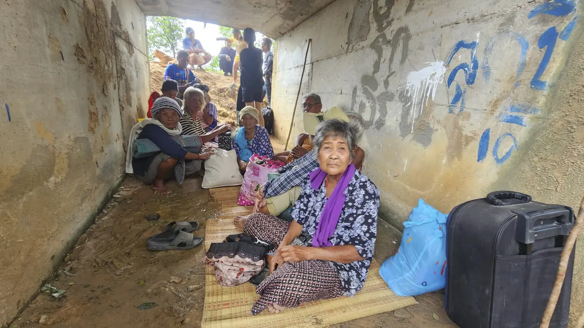 Thailand–Cambodia Border Conflict Escalates Today With Airstrikes and Civilian Casualties 2 Civillians ran for cover as Thailand clashes with Cambodian forces in Surin province, Thailand on Thursday. (Image Credit: AP)